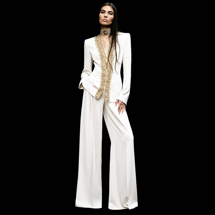 Woman wearing a white outfit with gold embellishments on a black background