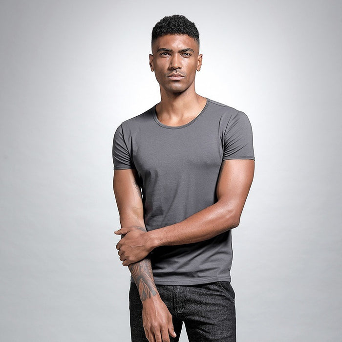 Man wearing a gray t-shirt against a plain background