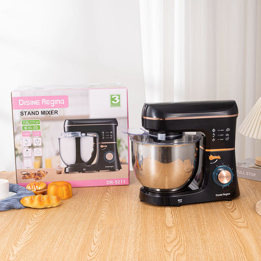 Black stand mixer on a wooden table with its packaging in the background
