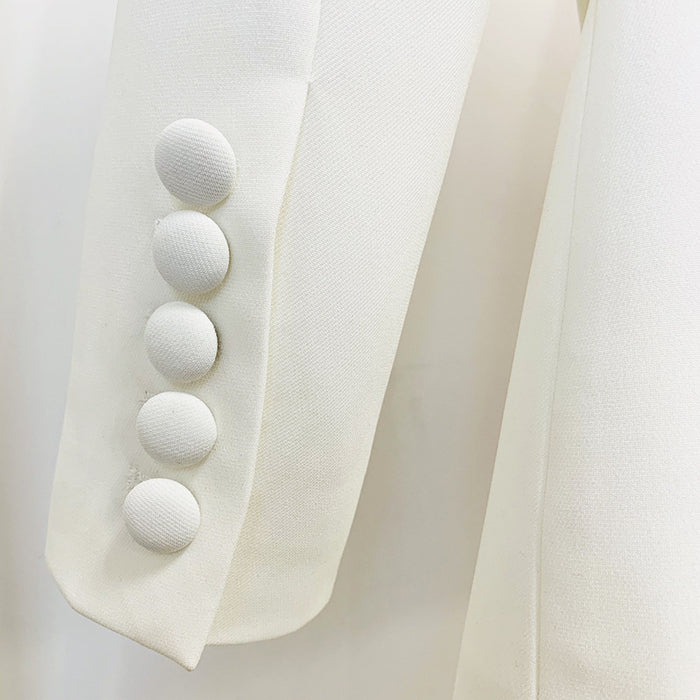 Close-up of a white blazer with button details on a light gray background