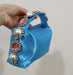 Blue handbag with decorative handle featuring pearls and pink stones held by a hand against a neutral background