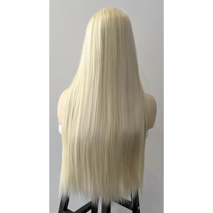 Blonde wig on a mannequin head against a gray background