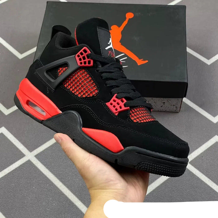 Black and red sneaker held in a hand with Jordan brand box in the background