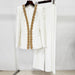 White outfit with gold embroidery on a hanger against a white background