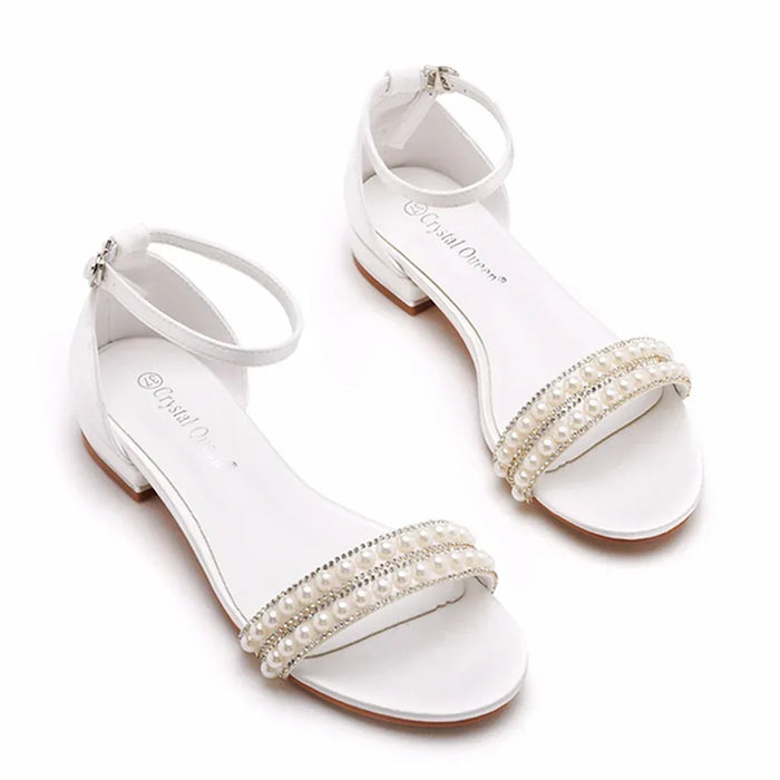 White sandals with pearl embellishments on a white background