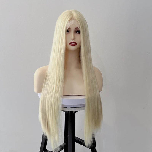 Blonde wig on a mannequin head against a plain background