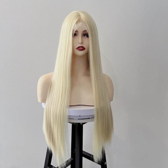 Blonde wig on a mannequin head against a plain background