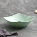 Green ceramic bowl with dimensions on a gray background