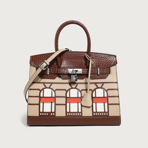 A handbag with a structured design featuring a mix of colors and geometric patterns, with a shoulder strap and a brand-embossed lock.