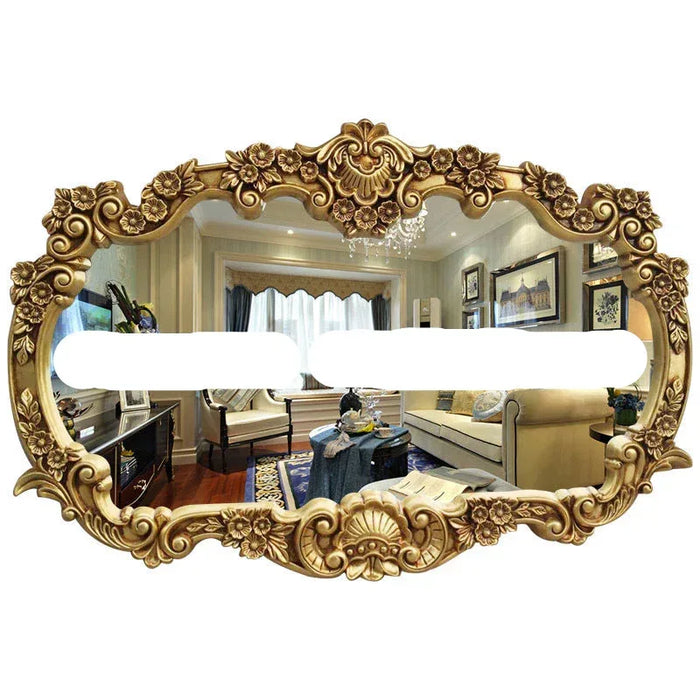 Decorative gold mirror with intricate designs reflecting a living room.