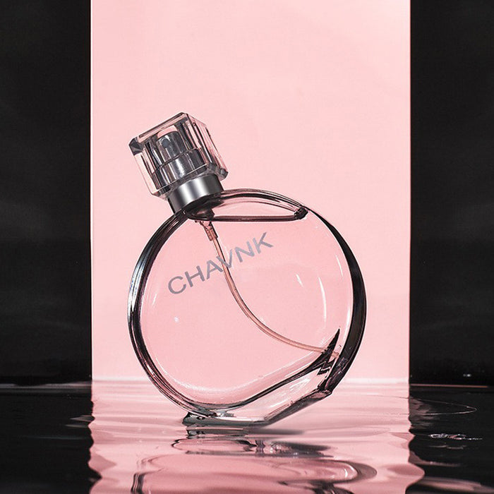 Perfume bottle with 'CHAVAN' branding on a reflective surface with a pink background