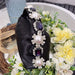 Decorative black bag with pearls and purple stones on a floral background