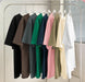 Row of shirts in various colors hanging on a rack.