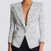 Textured blazer with a gold button on a plain background