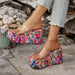 Colorful platform shoes worn by a person with a stone wall and flowers in the background
