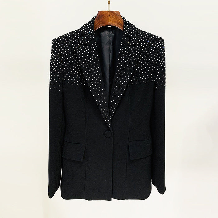 Black blazer with white polka dot lapels on a wooden hanger against a white background