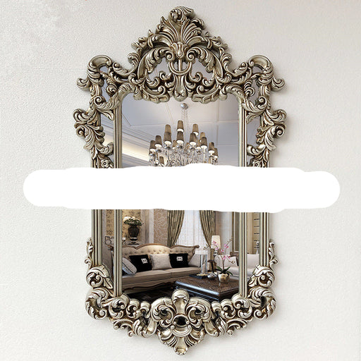 Decorative wall mirror with intricate gold frame in a room setting