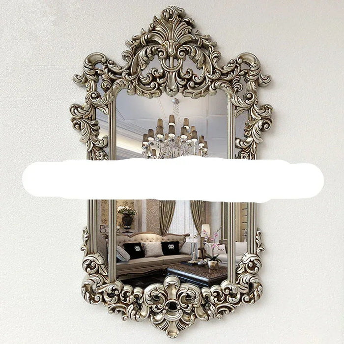 Decorative wall mirror with intricate gold frame in a room setting