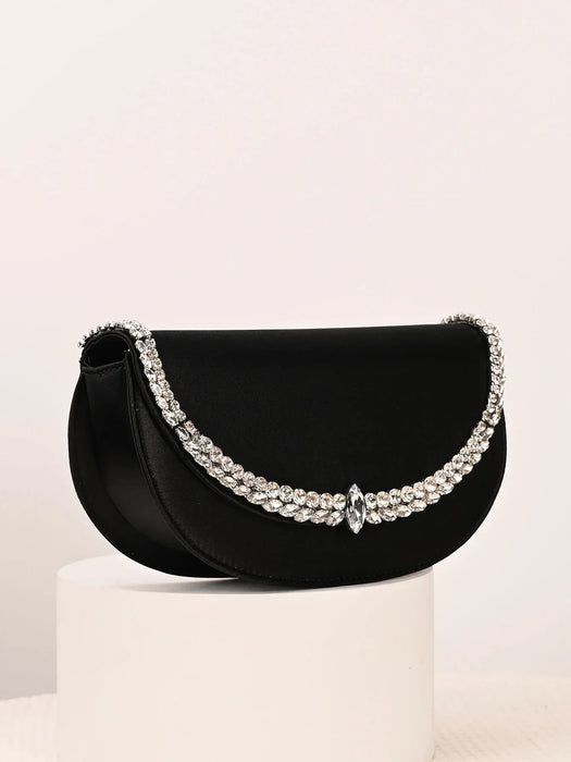 Black handbag with decorative elements on a light background