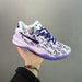 White sneaker with purple accents held by a hand against a gray background