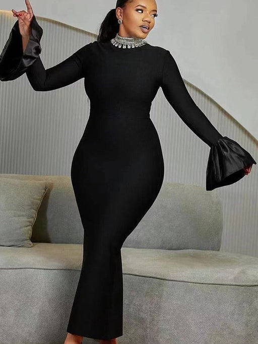A woman wearing a black long-sleeve dress with a round neckline and a high waist, featuring a solid color with a zipper at the placket.
