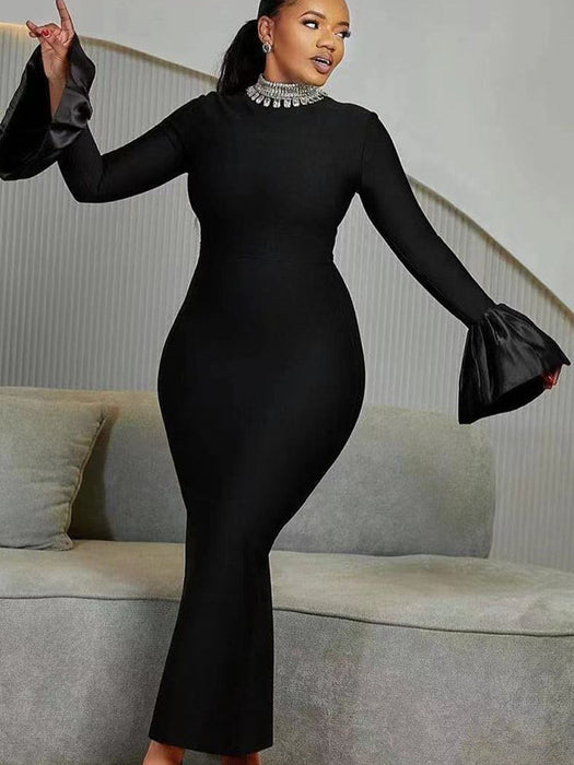 A woman wearing a black long-sleeve dress with a round neckline and a high waist, featuring a solid color with a zipper at the placket.