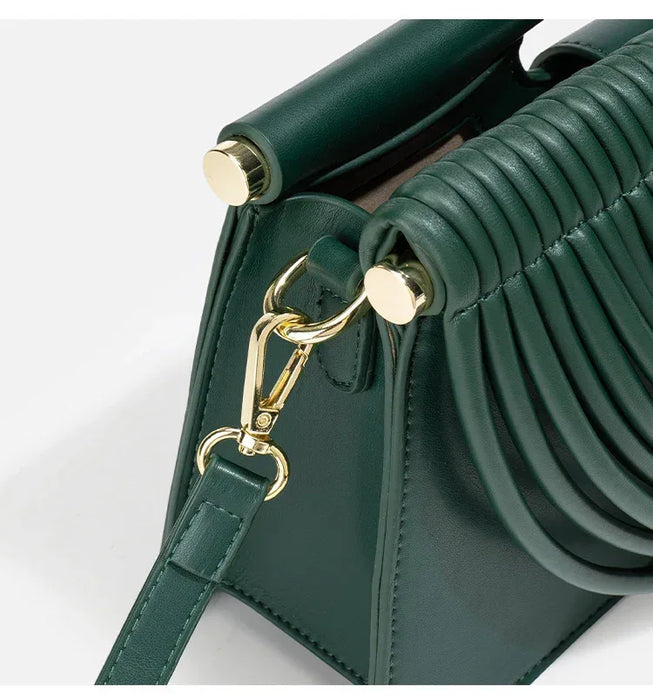 Green handbag with gold hardware on a white background