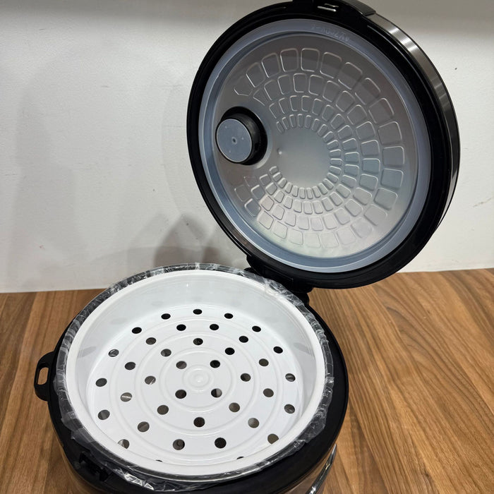Black and white steamer basket with lid on a wooden surface
