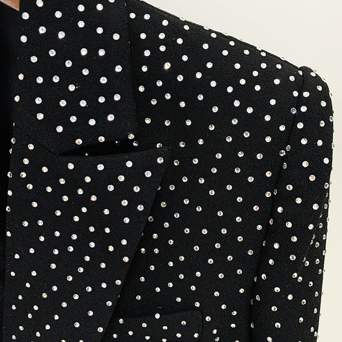 Black blazer with white polka dot pattern on a neutral background