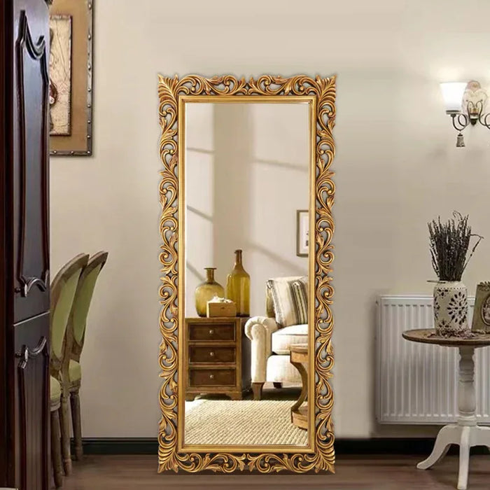 Decorative gold-framed mirror in a room with furniture and decor.