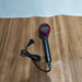 Black hair dryer with purple accents on a wooden surface
