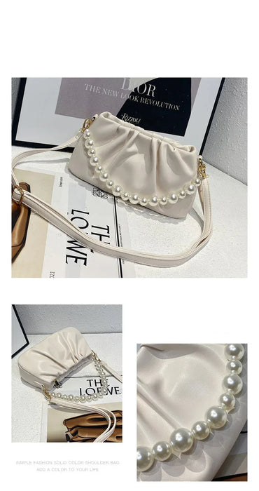 White handbag with pearl embellishments on a magazine background