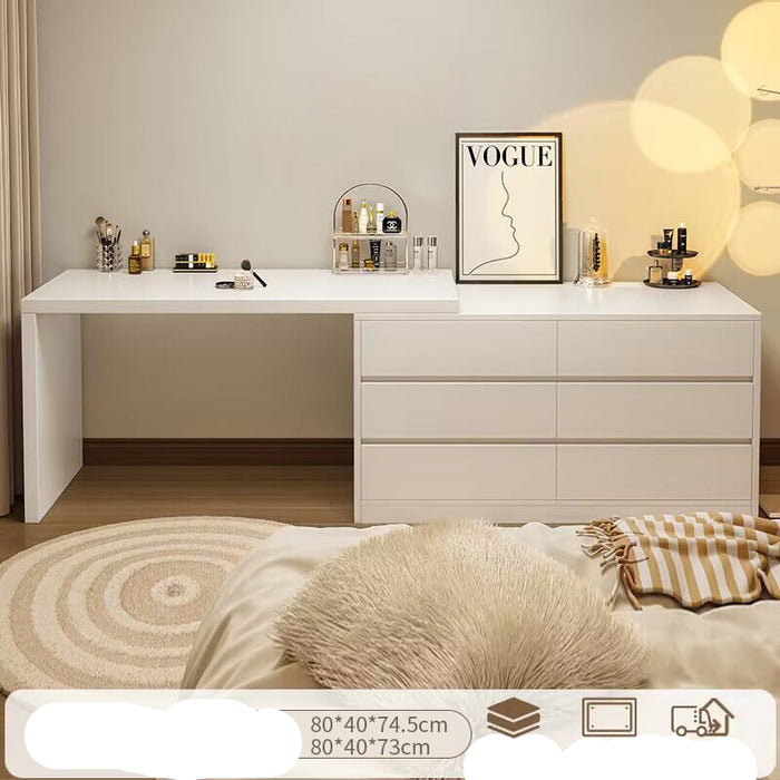 White dresser with multiple drawers in a bedroom setting, featuring decor items and a 'Vogue' poster.