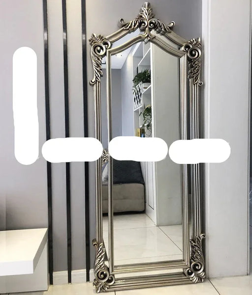 Decorative full-length mirror with ornate frame in a room setting