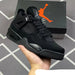 Black sneaker held in hand with Jordan box in the background