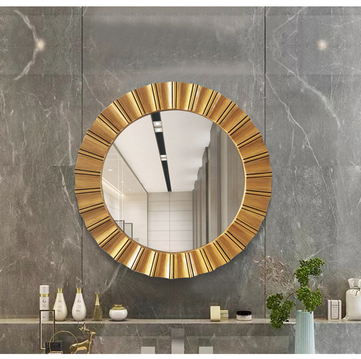 Round gold-framed mirror on a gray marble wall