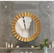 Round gold-framed mirror on a gray marble wall