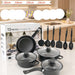 A 13-piece cookware set displayed in front of its retail box, featuring black non-stick pots, pans, lids, and utensils, with a kitchen background.