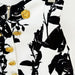 Black and white floral patterned fabric with gold buttons on a white background
