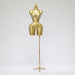 Gold mannequin torso on a stand against a white background
