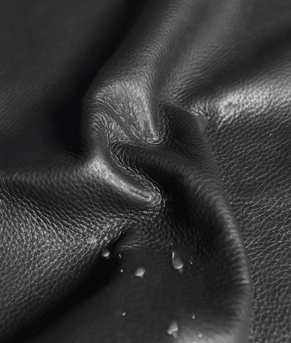 Close-up of black leather texture with water droplets