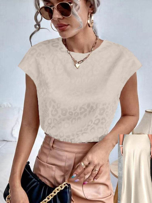 Woman wearing a beige lace top and pink pants with sunglasses and a handbag.