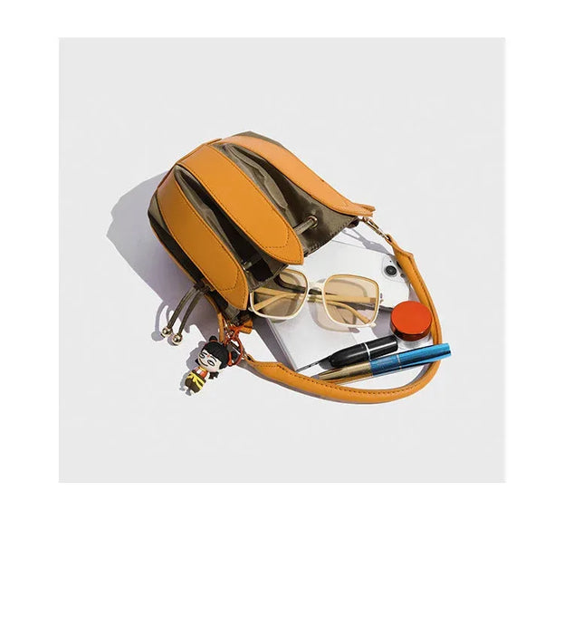 Orange pouch with sunglasses, pen, and other items on a light gray background