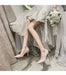 Bride in a wedding dress with high-heeled shoes and a bouquet, sitting on a chair.
