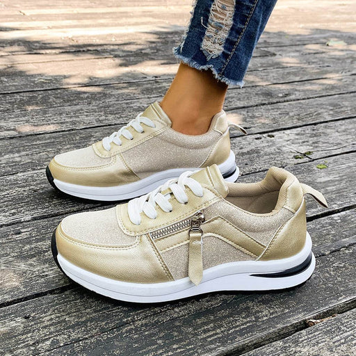 Beige sneakers with white laces on a wooden floor