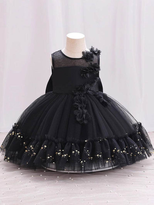 Black dress with floral details on a mannequin against a white background