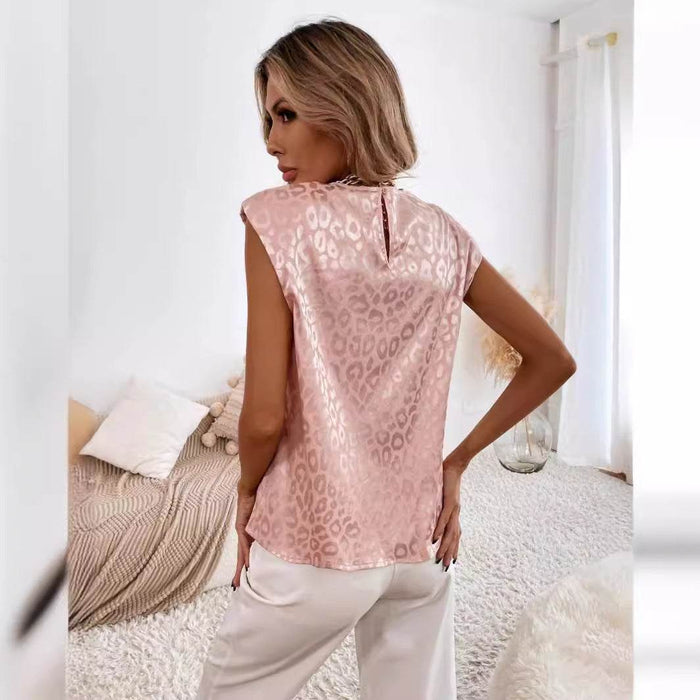 Woman wearing a pink leopard print top in a bedroom setting