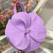 Purple flower-shaped handbag with floral background