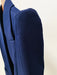Close-up of a blue blazer on a beige background