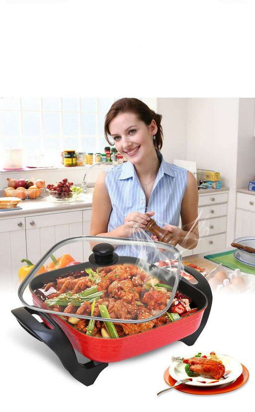 Woman in a kitchen with a large cooking pot containing food, smiling at the camera.